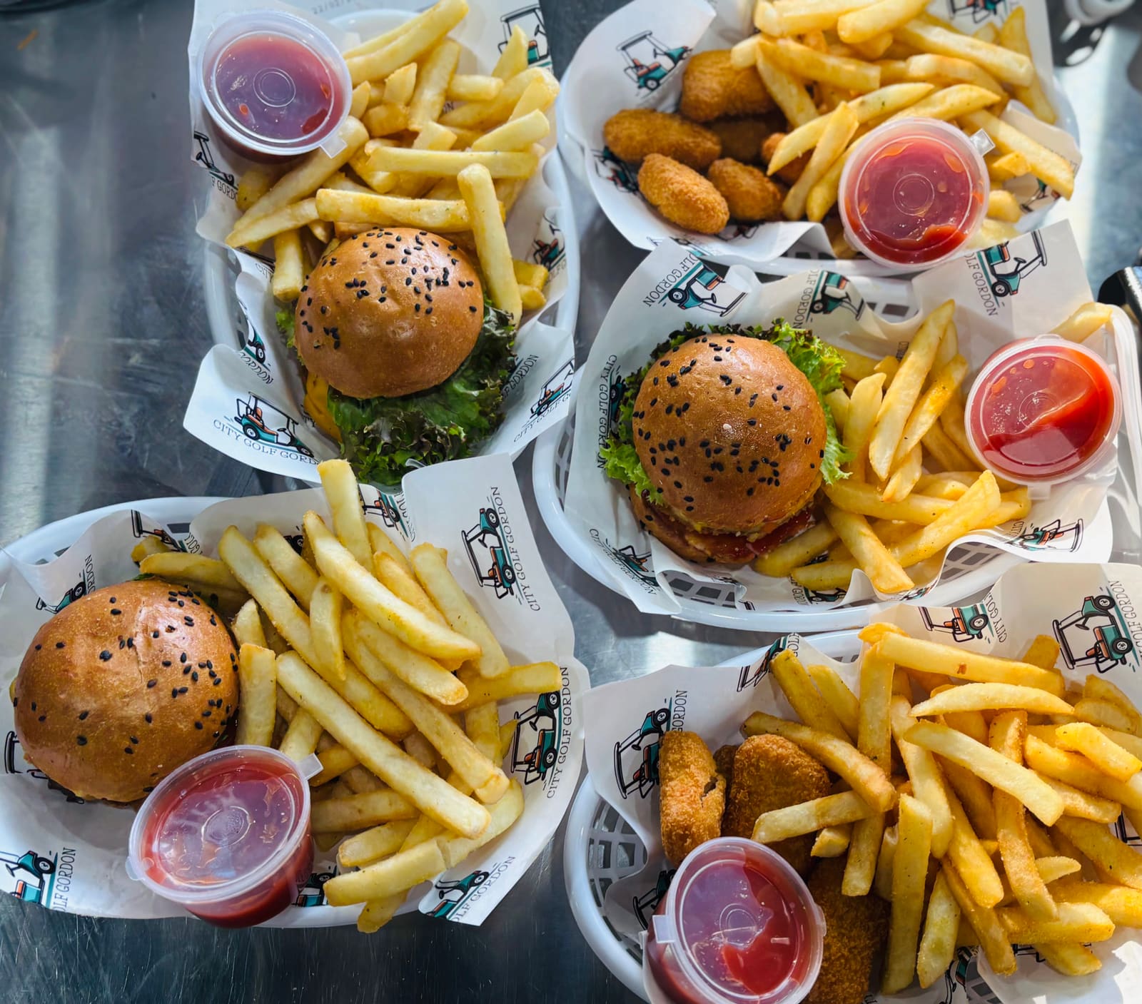 Boxes of hamburger sliders and chips with sauces