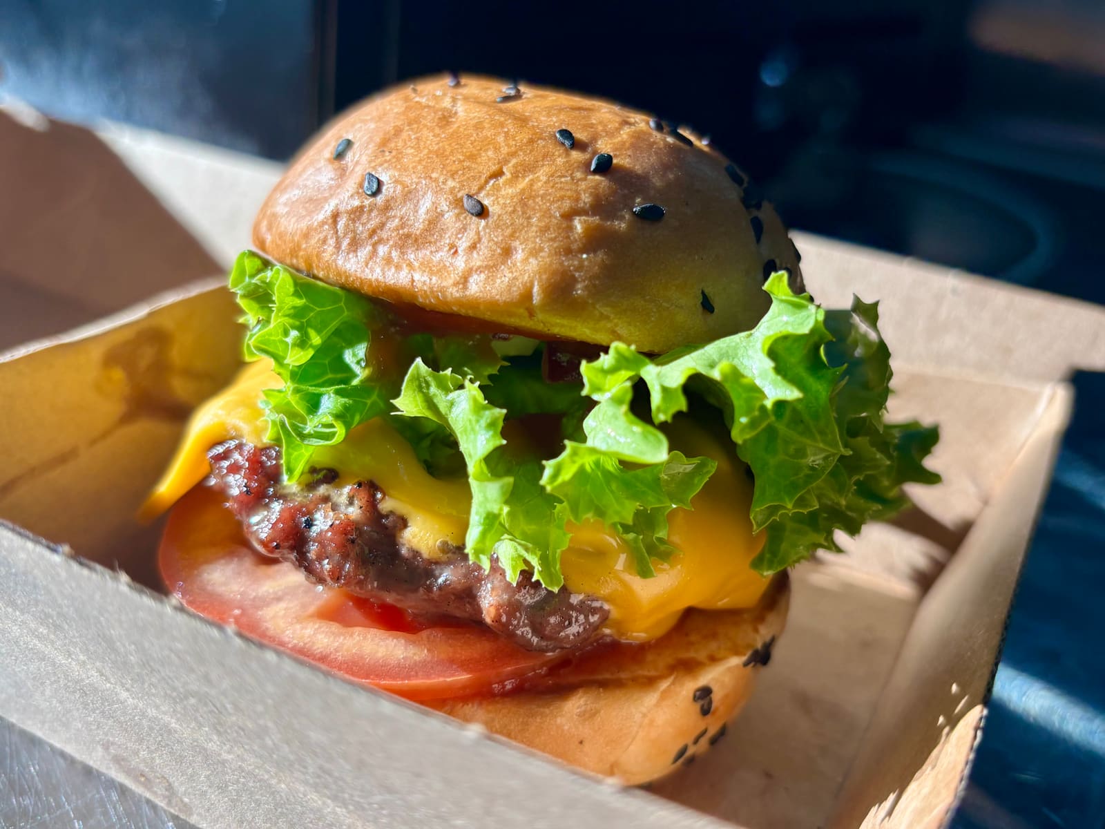 A hamburger slider in a takeaway box at City Golf Gordon